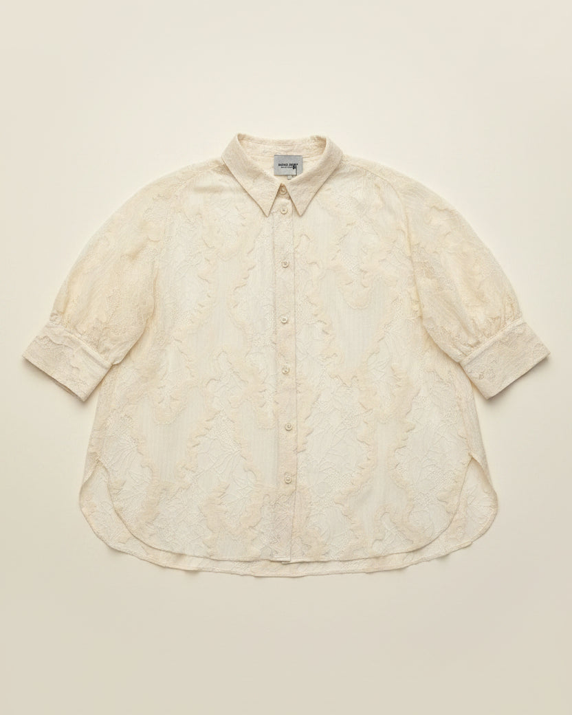 An off-white textured button-up shirt with short puff sleeves, laid flat against a solid cream background.