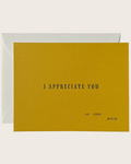 A square yellow greeting card with the text 'I APPRECIATE YOU SO VERY MUCH' printed in black, shown with a white envelope behind it on a light beige background.