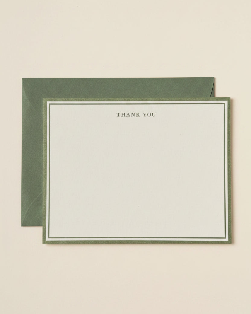 A minimalist thank you card with a cream-colored center and a sage green border, shown with a matching sage green envelope behind it on a white background.